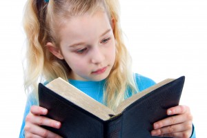 little girl is reading the Bible